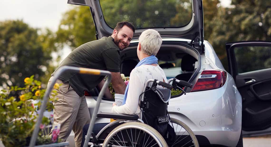 Man putting flowers into the boot of his car