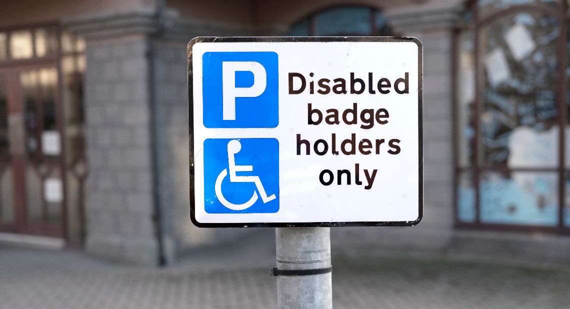 Disabled badge holders only sign parking space in car park at shops