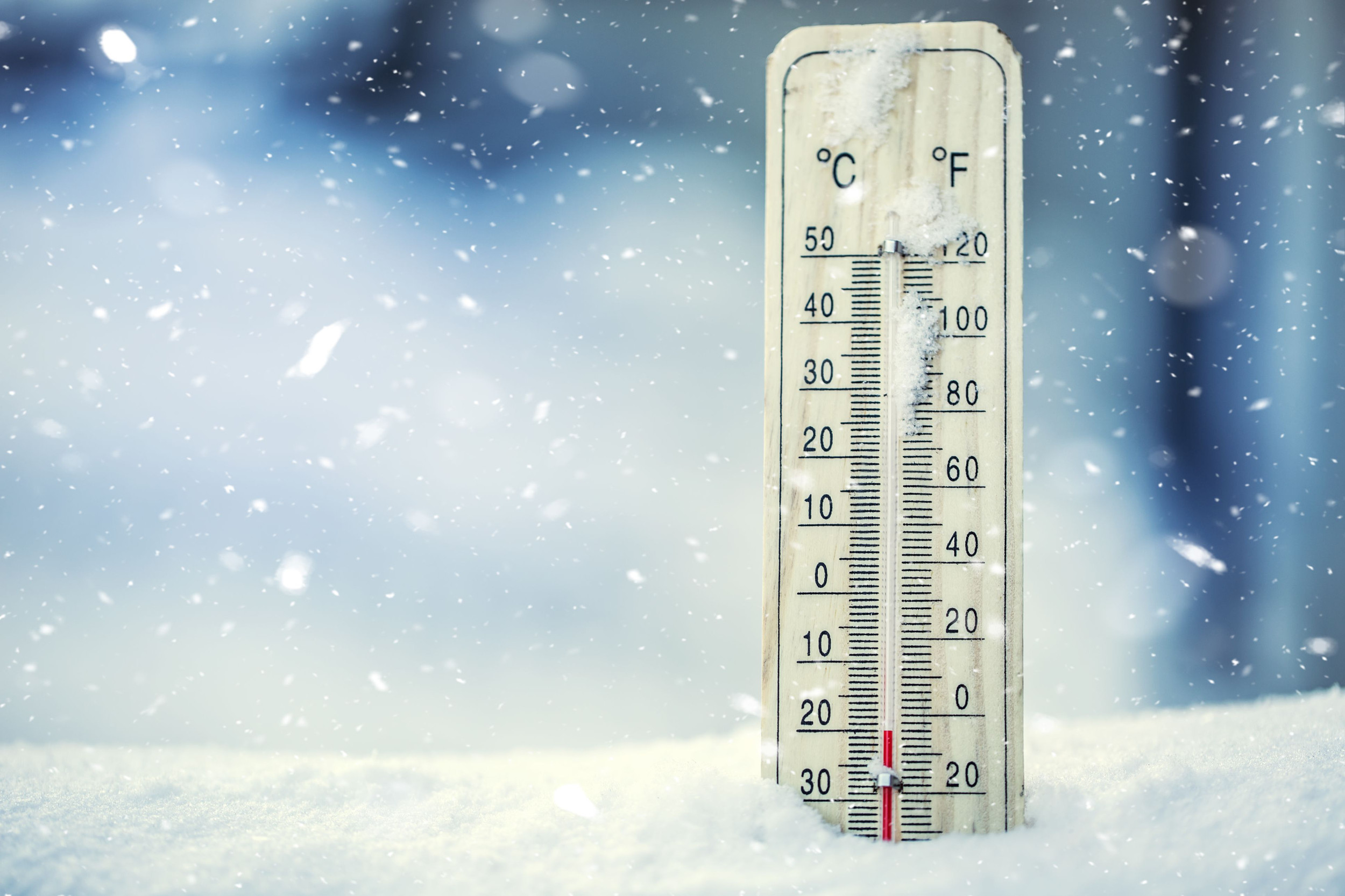 Thermometer on snow shows temperature drop below zero