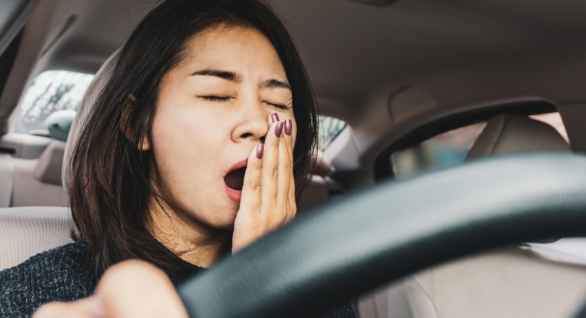 Tired sleepy woman yawning during driving car