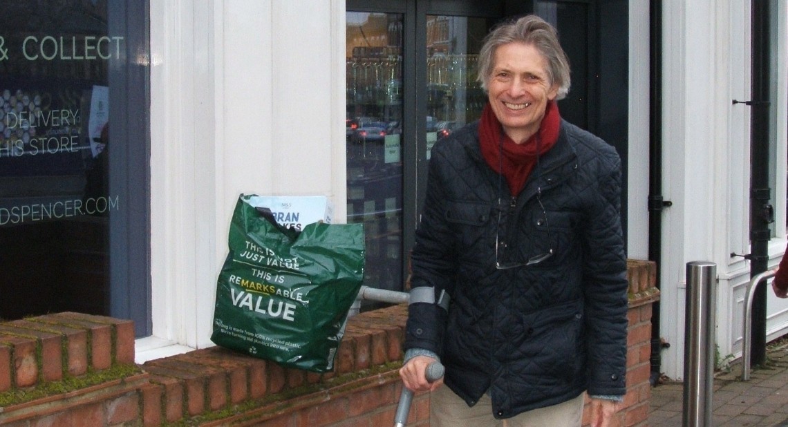 Ian Cook looking happy and standing outside M&S with his shopping bags.
