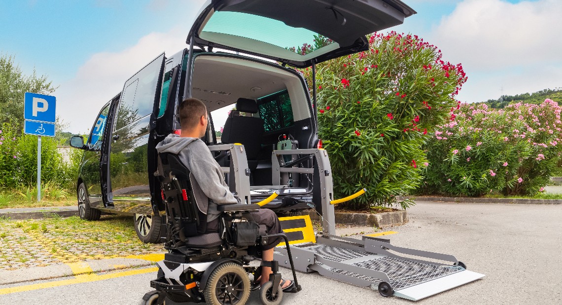 Wheelchair Accessible Vehicle with a wheelchair lift ramp deployed for a man to enter in his wheelchair
