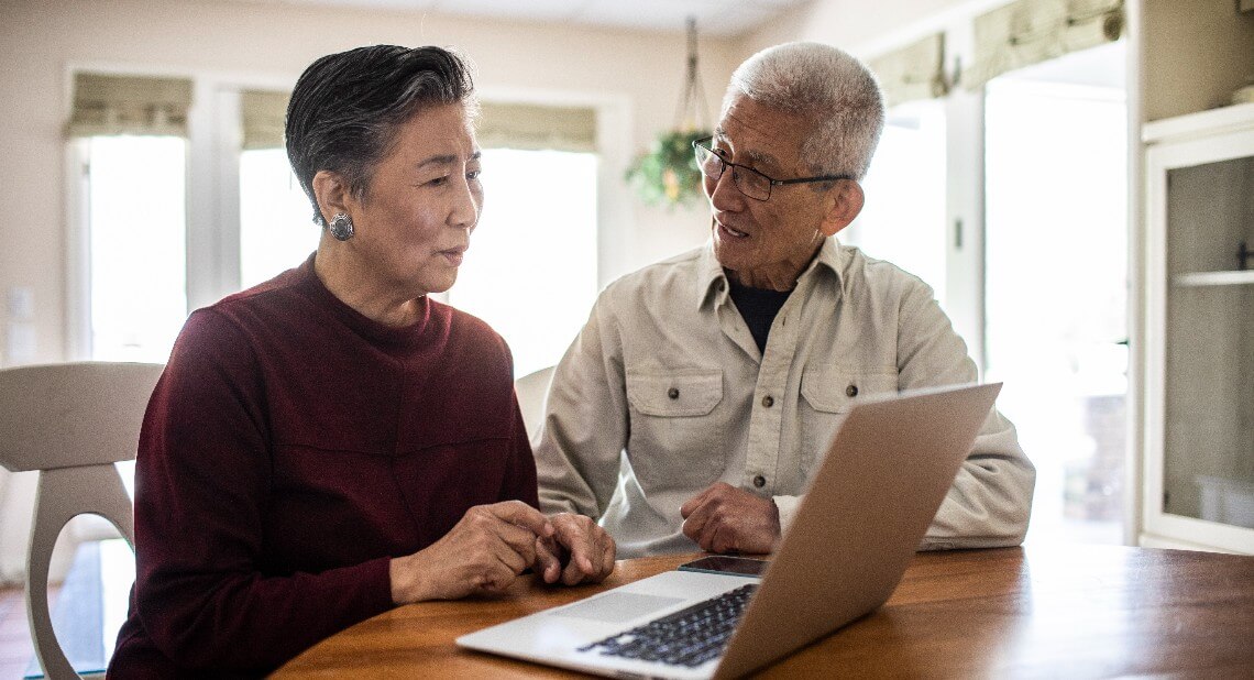 Senior couple using laptop computer at home