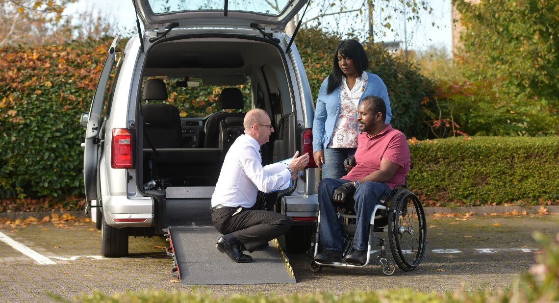 WAV supplier speaking to a customer in a wheelchair next to a WAV
