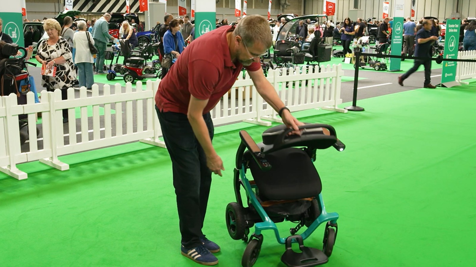 Jim Wood showing a demonstration of a powered wheelchair folding down