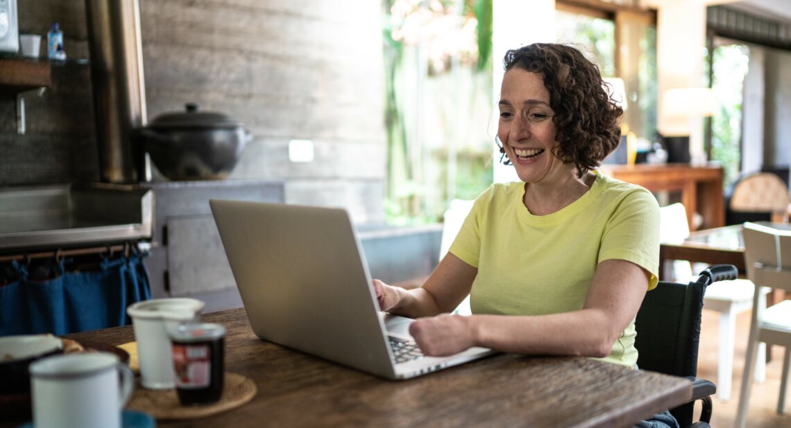 Woman sitting at her laptop smiling