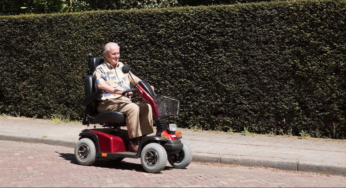 Man on a mobility scooter driving on the road