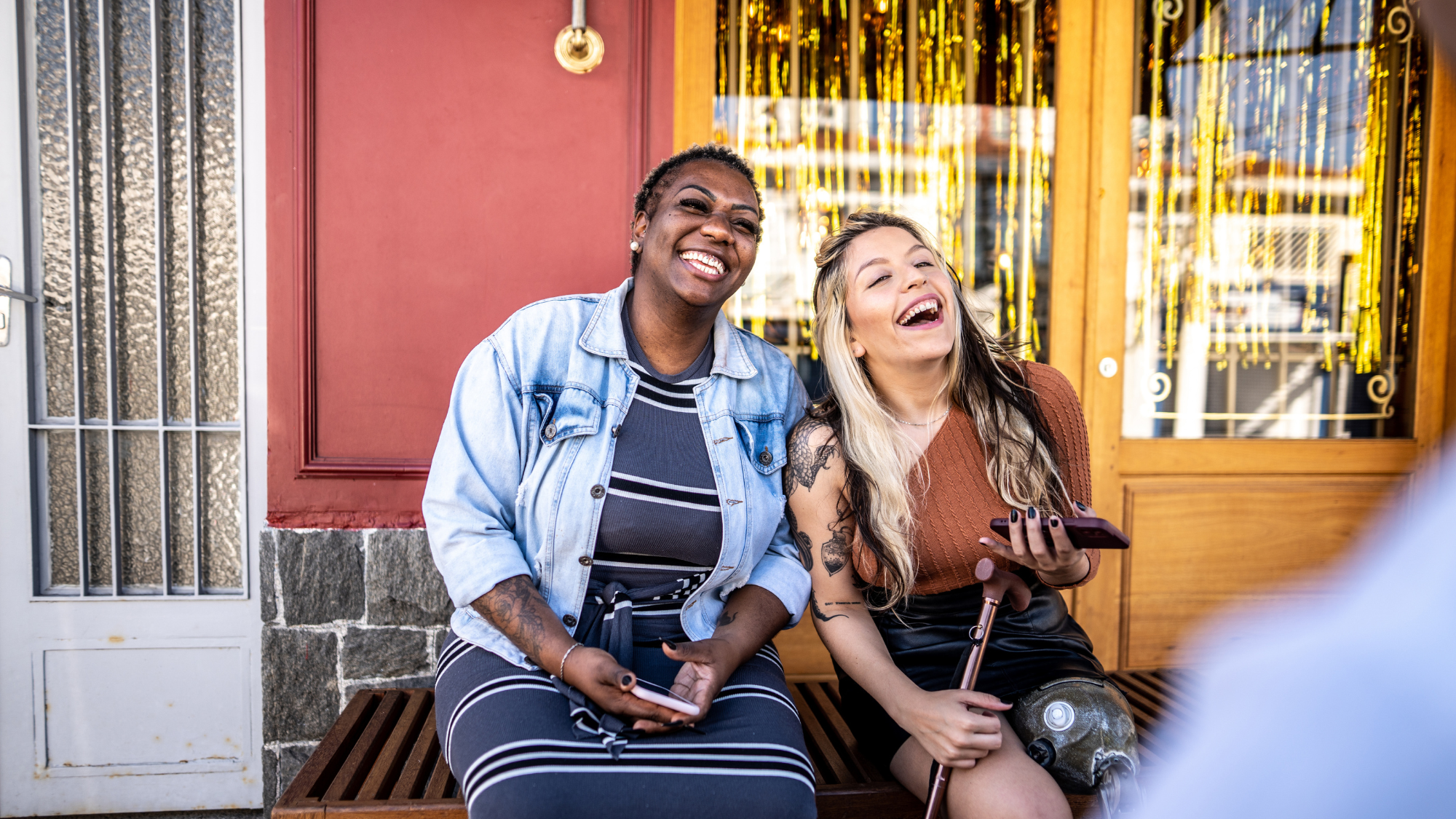 Two women sitting down laughing together