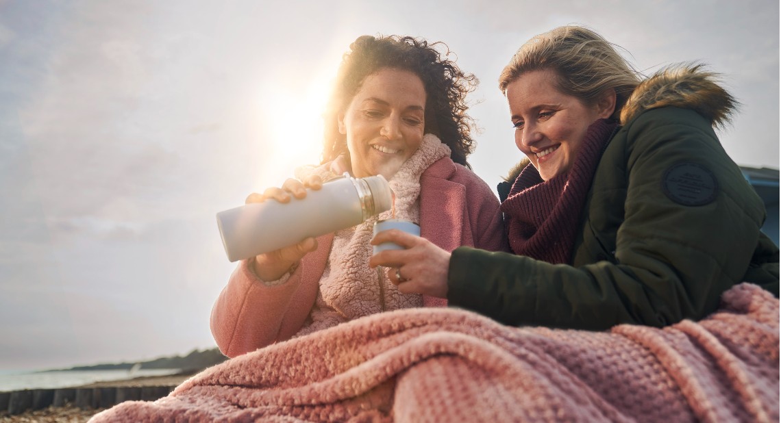 two ladies under a blanket in cold weather