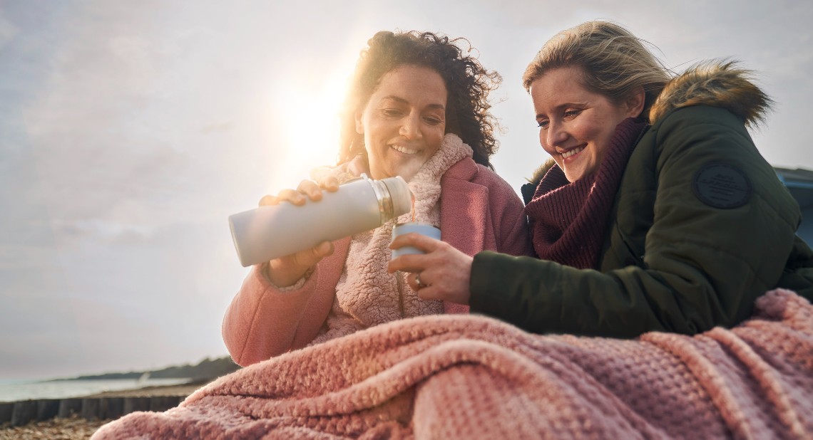 Two ladies in the cold weather under a blanket