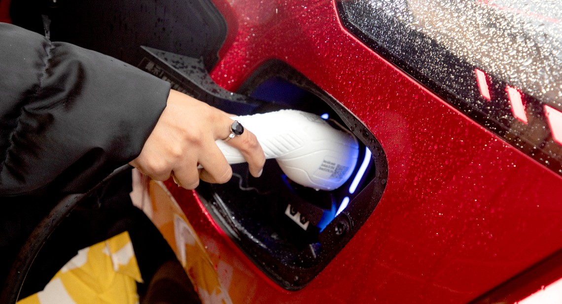 An electric car charger plugged into a car