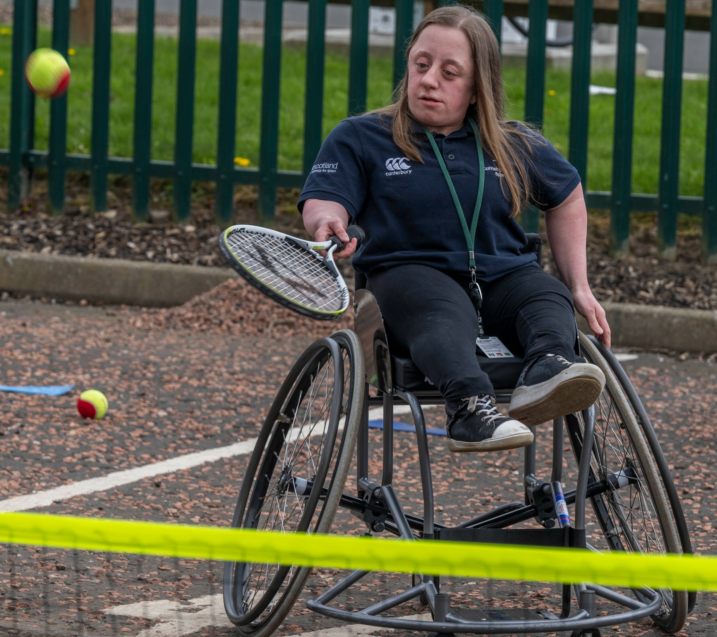 A wheelchair user playing tennis