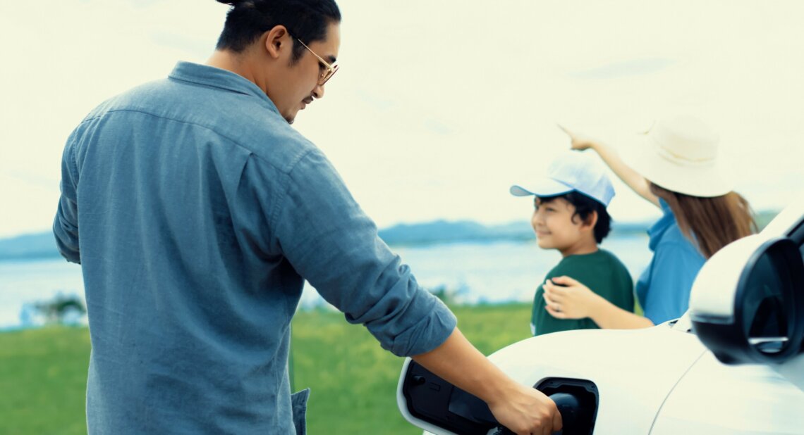 A man in a blue shirt charging his EV