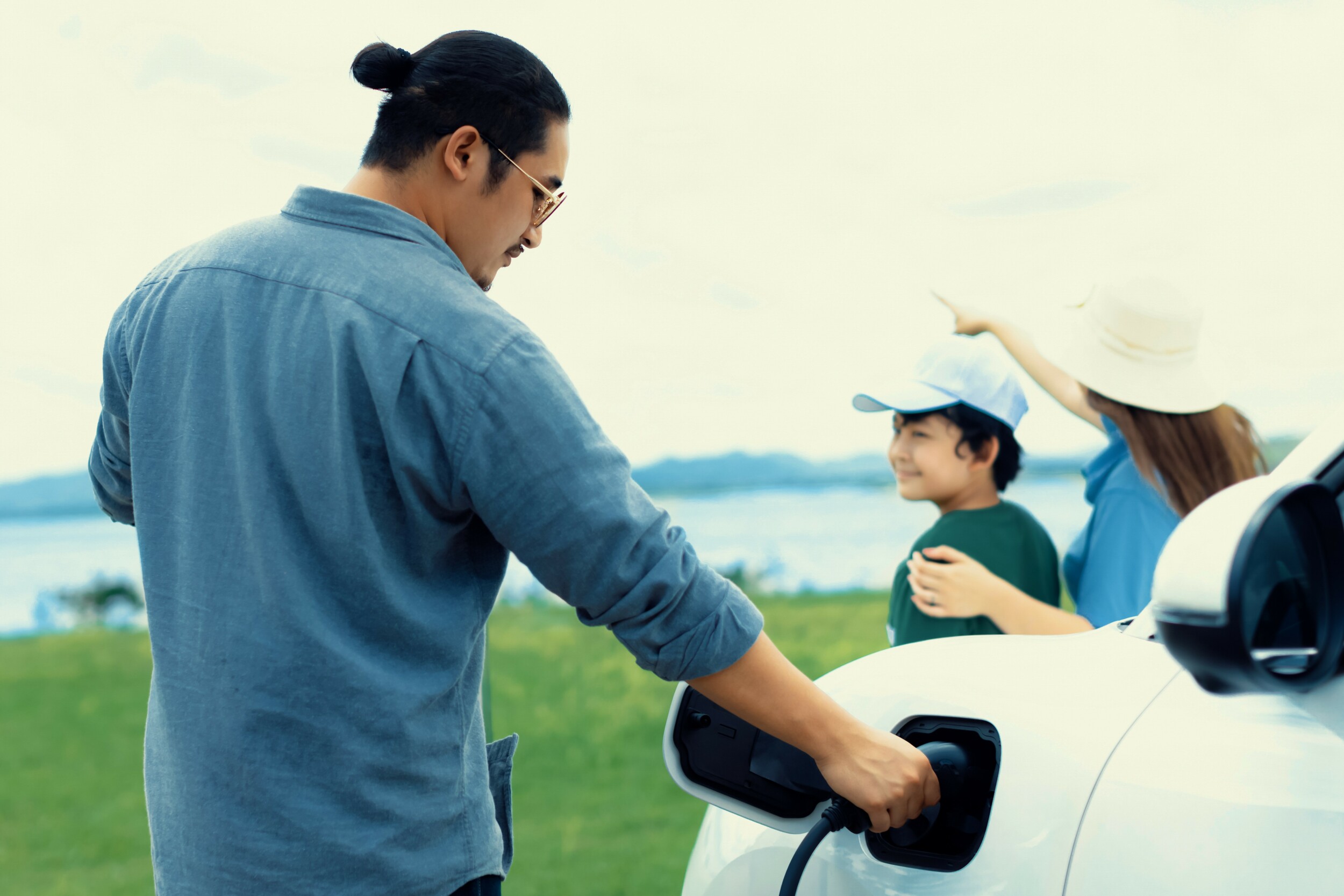 A man in a blue shirt charging his EV