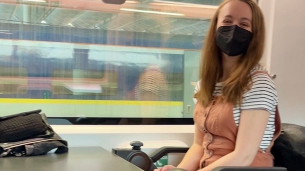 Pippa Stacey smiling with a face covering on while travelling on the Eurostar train