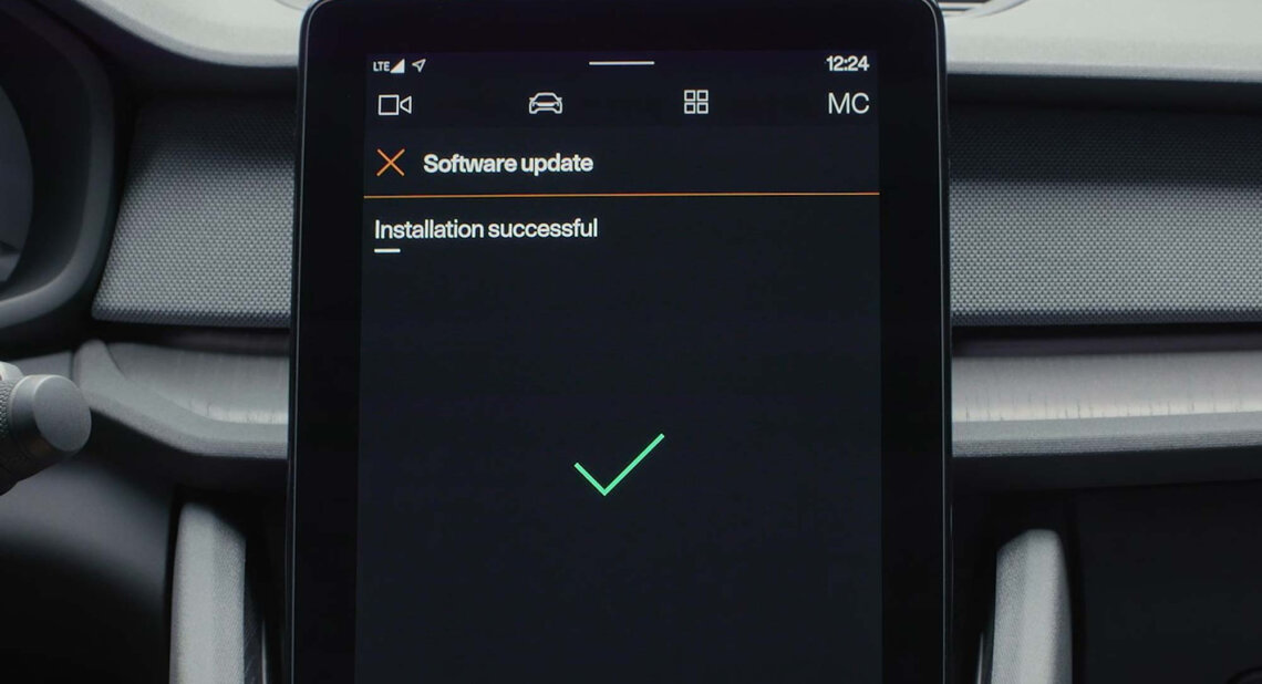 A digital car dashboard screen displays a message reading “Software update – Installation successful,” with a large green check mark below it.