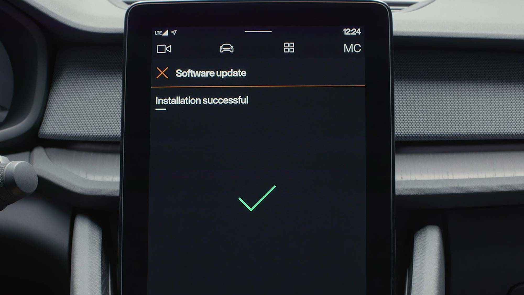 A digital car dashboard screen displays a message reading “Software update – Installation successful,” with a large green check mark below it.