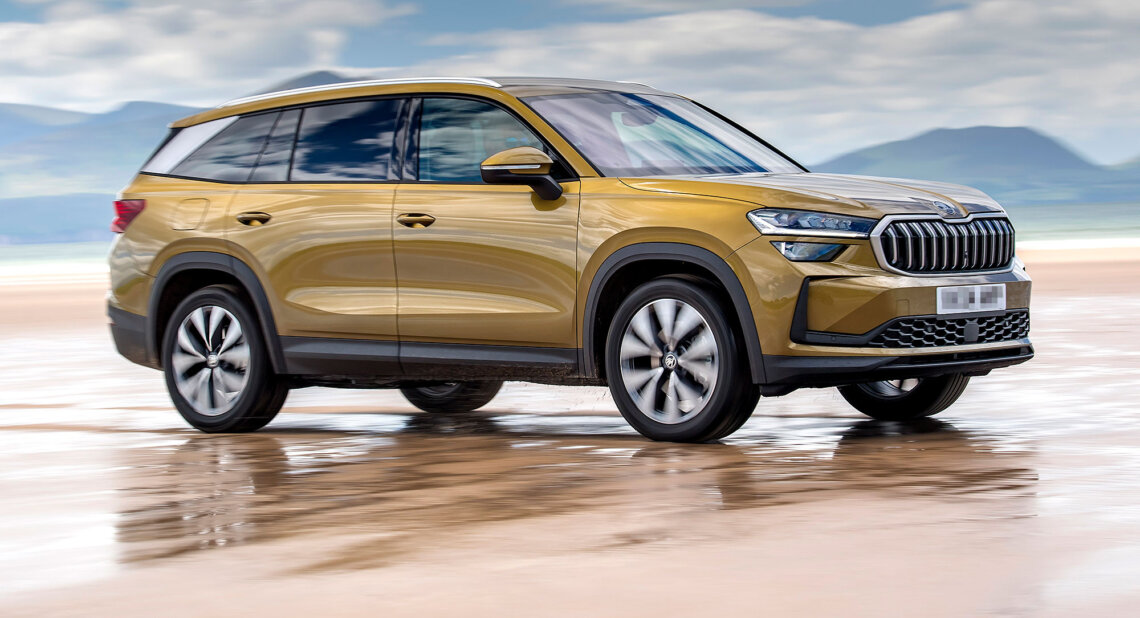 A gold Škoda Kodiaq driving along a wet sandy surface, with reflections beneath the SUV and a strong chrome grille.