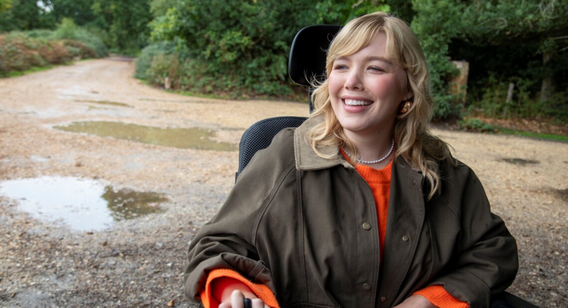 Woman using powered wheelchair smiling