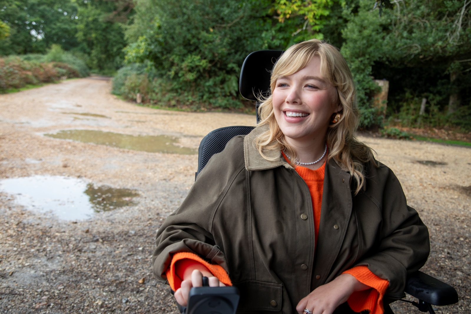 Woman using powered wheelchair smiling