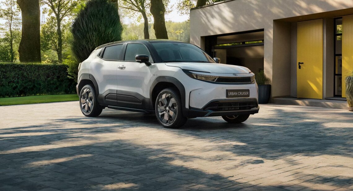 White Toyota Urban Cruiser parked on a driveway outside a modern house, with trees and greenery in the background.